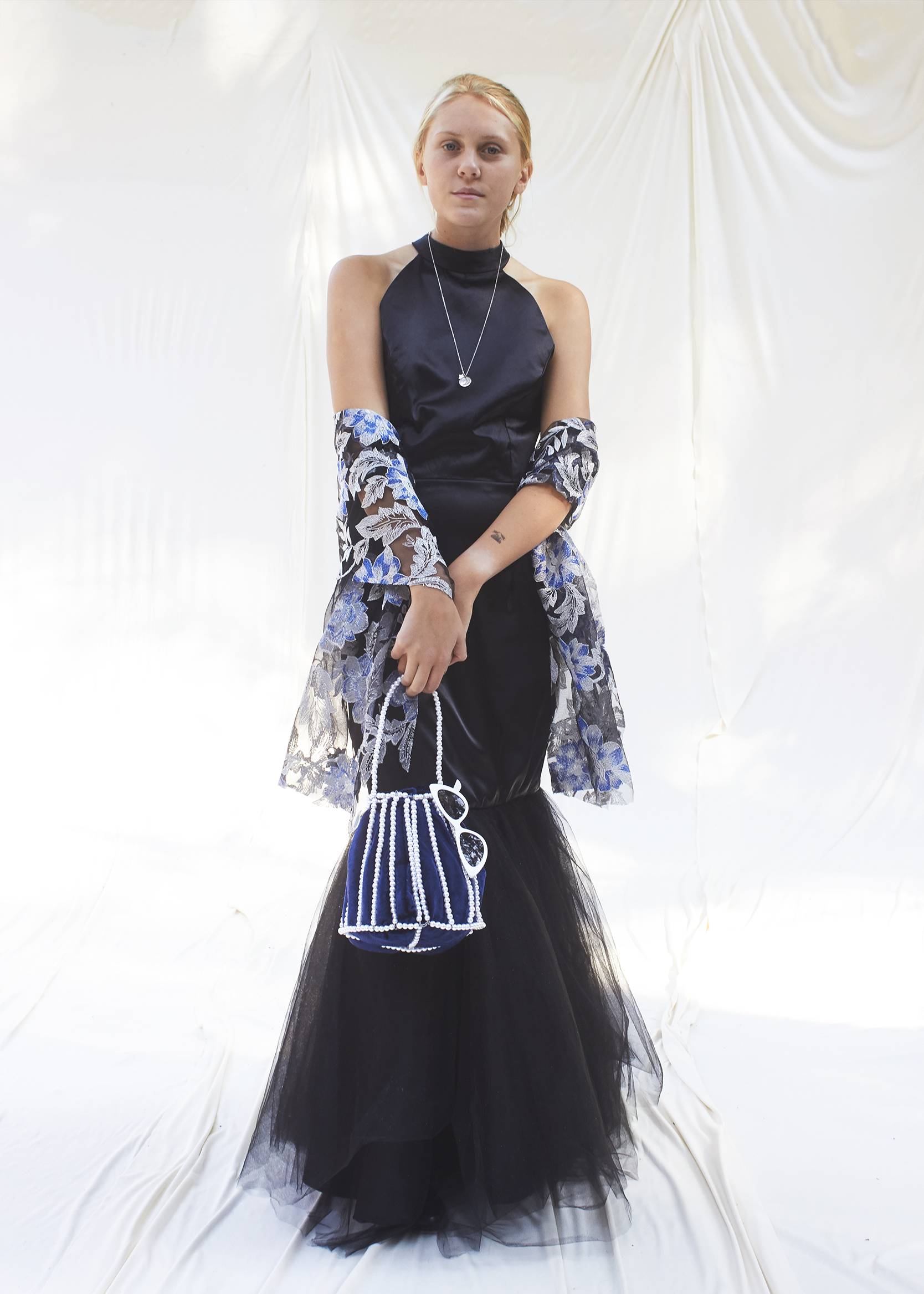 Girl posing in a black halter gown with tulle bottom and brocade shawl