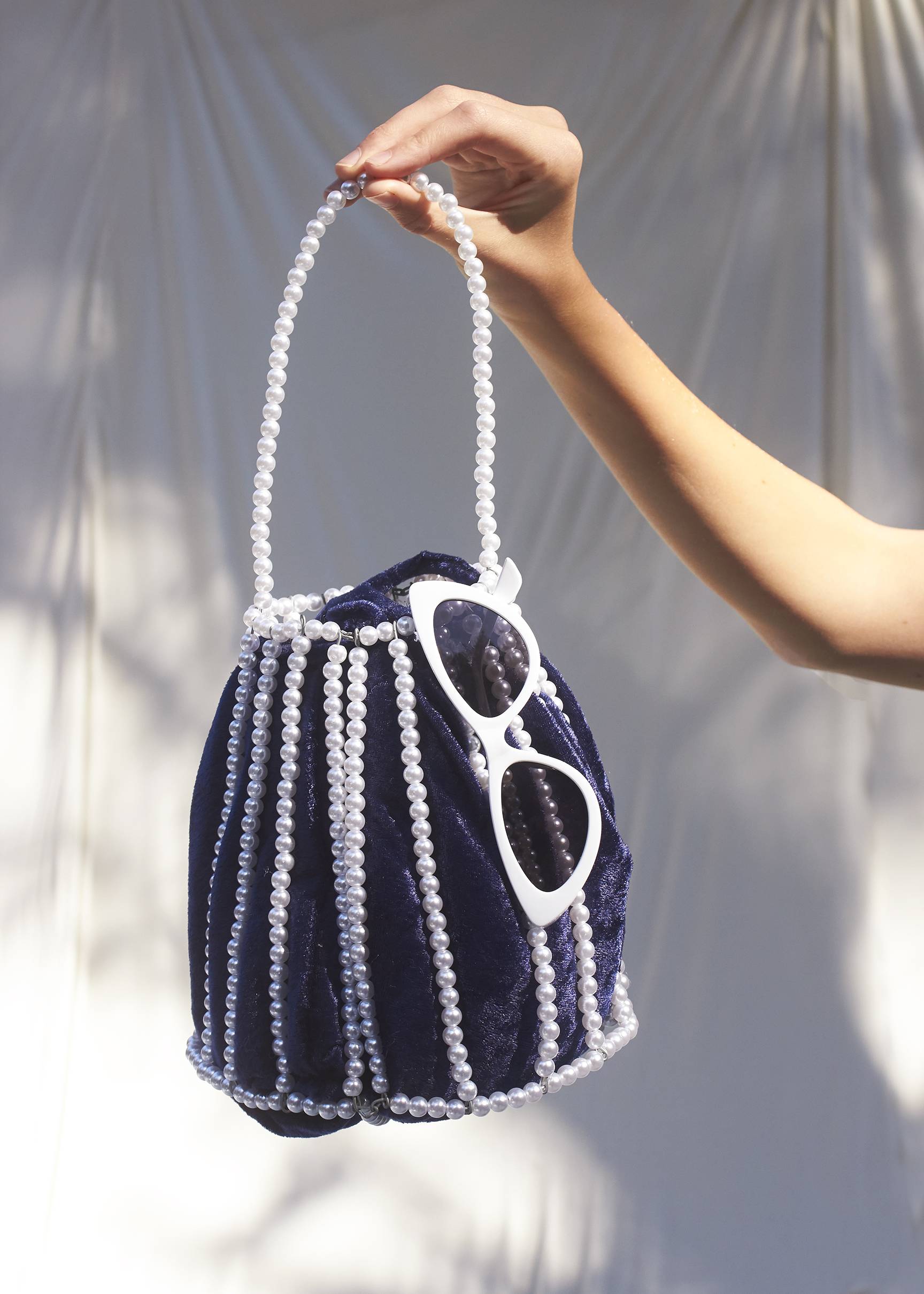 Beaded blue and white bag with white sunglasses