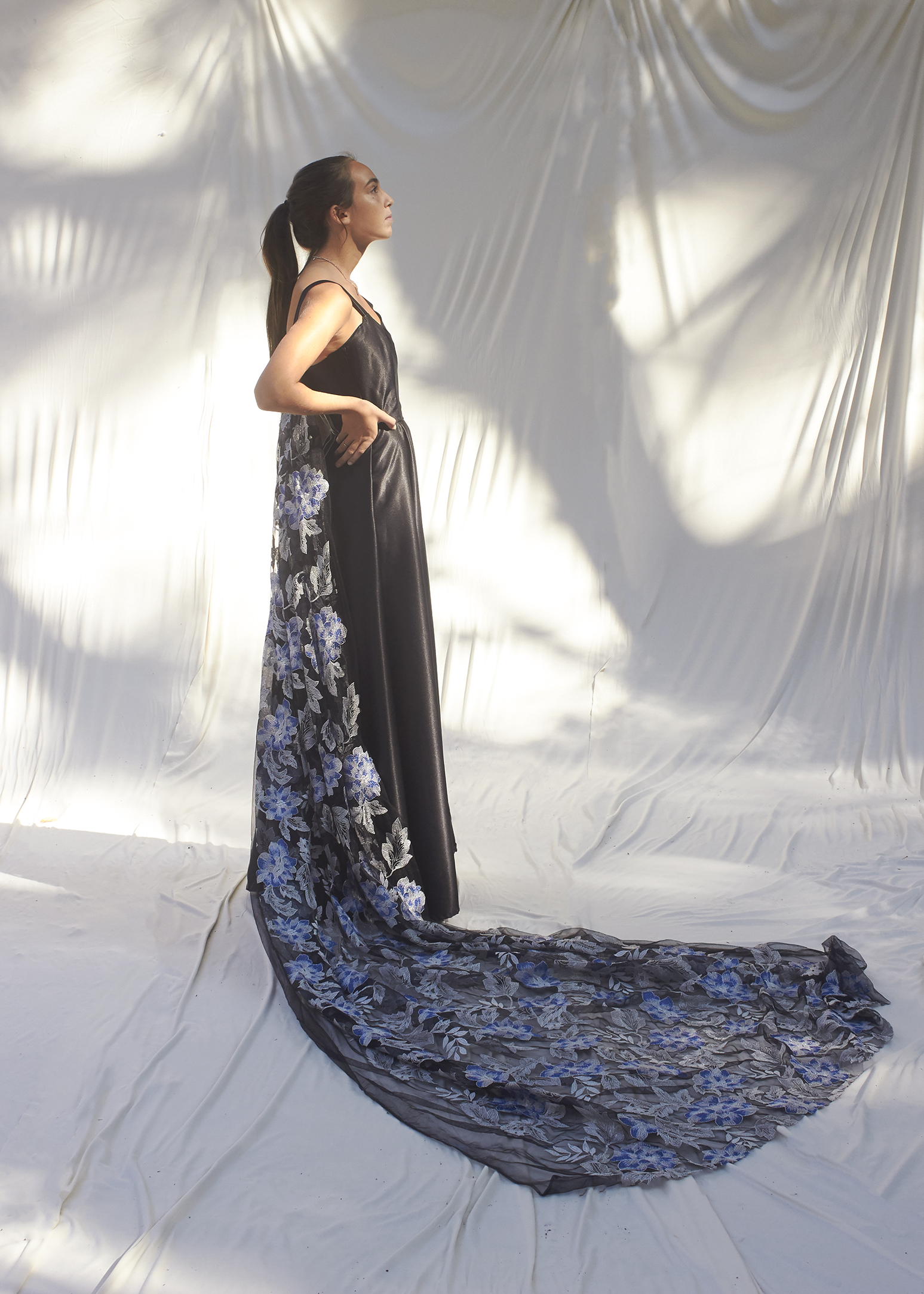 Side view of girl in black gown and brocade train