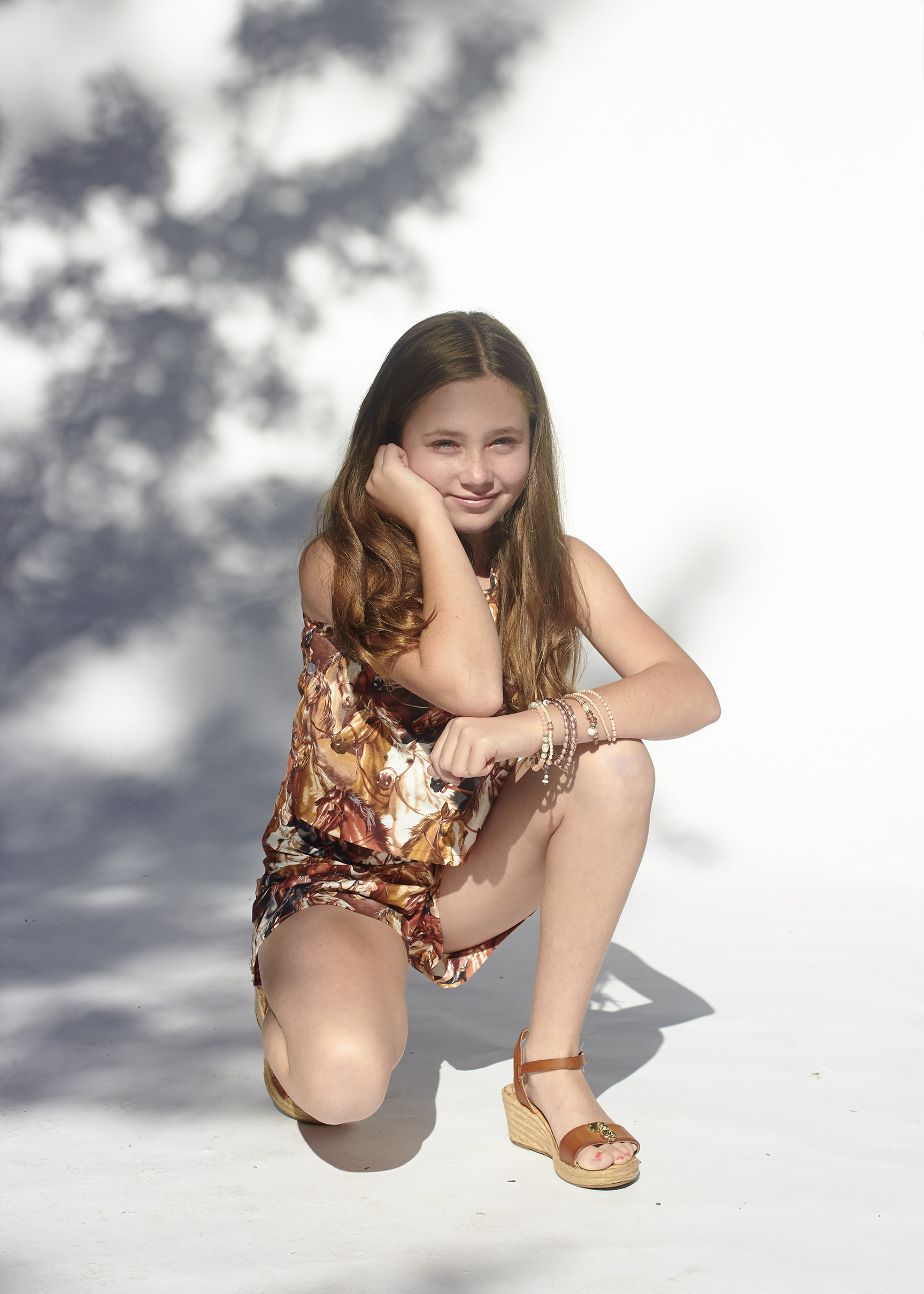 Girl kneeling in horse print top and matching shorts