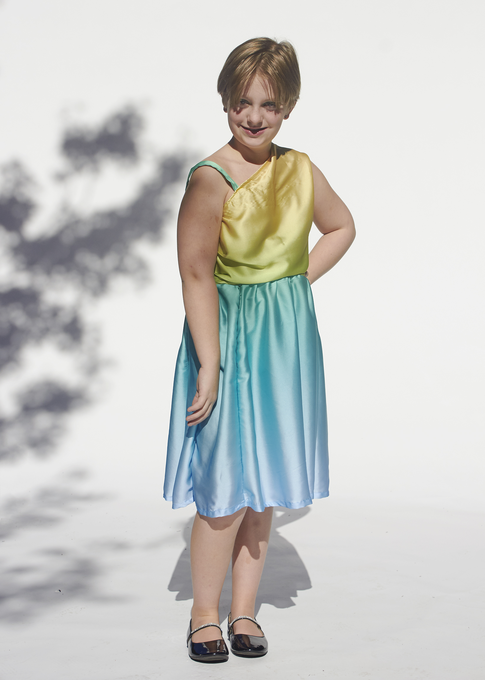 front view of girl in a one shoulder yellow and blue satin dress