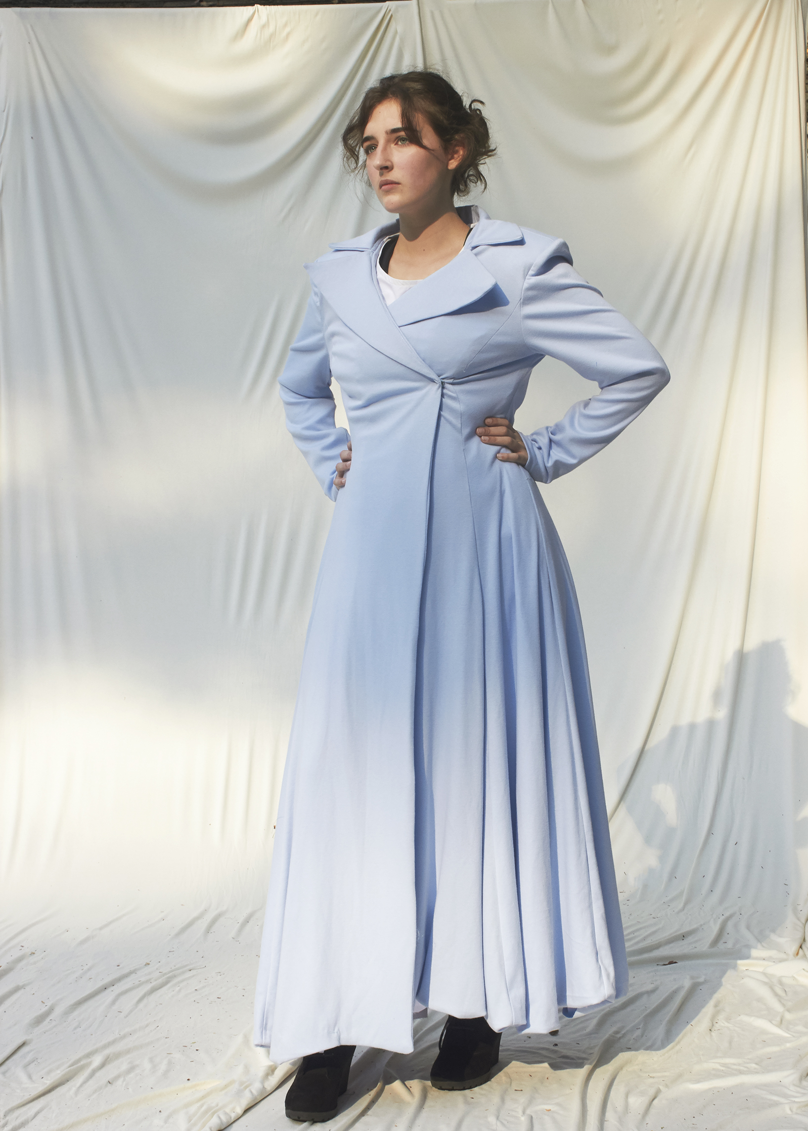 Photo of girl posing in floor length sky blue tailored coat