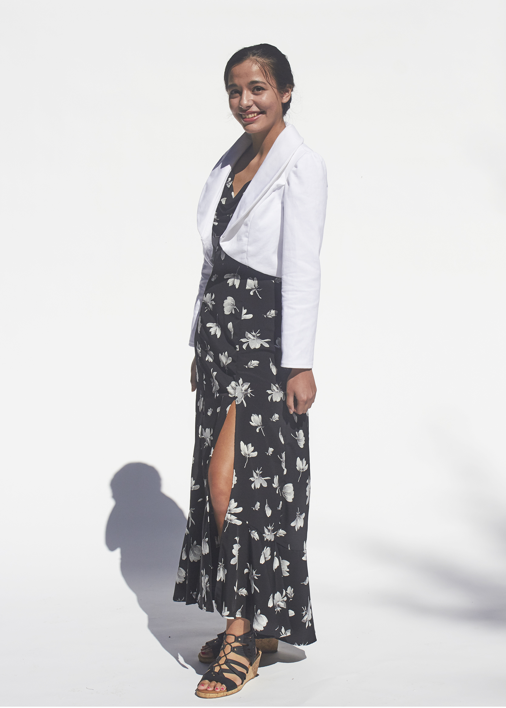 Black dress with slit and white floral pattern with shawl collared white denim jacket