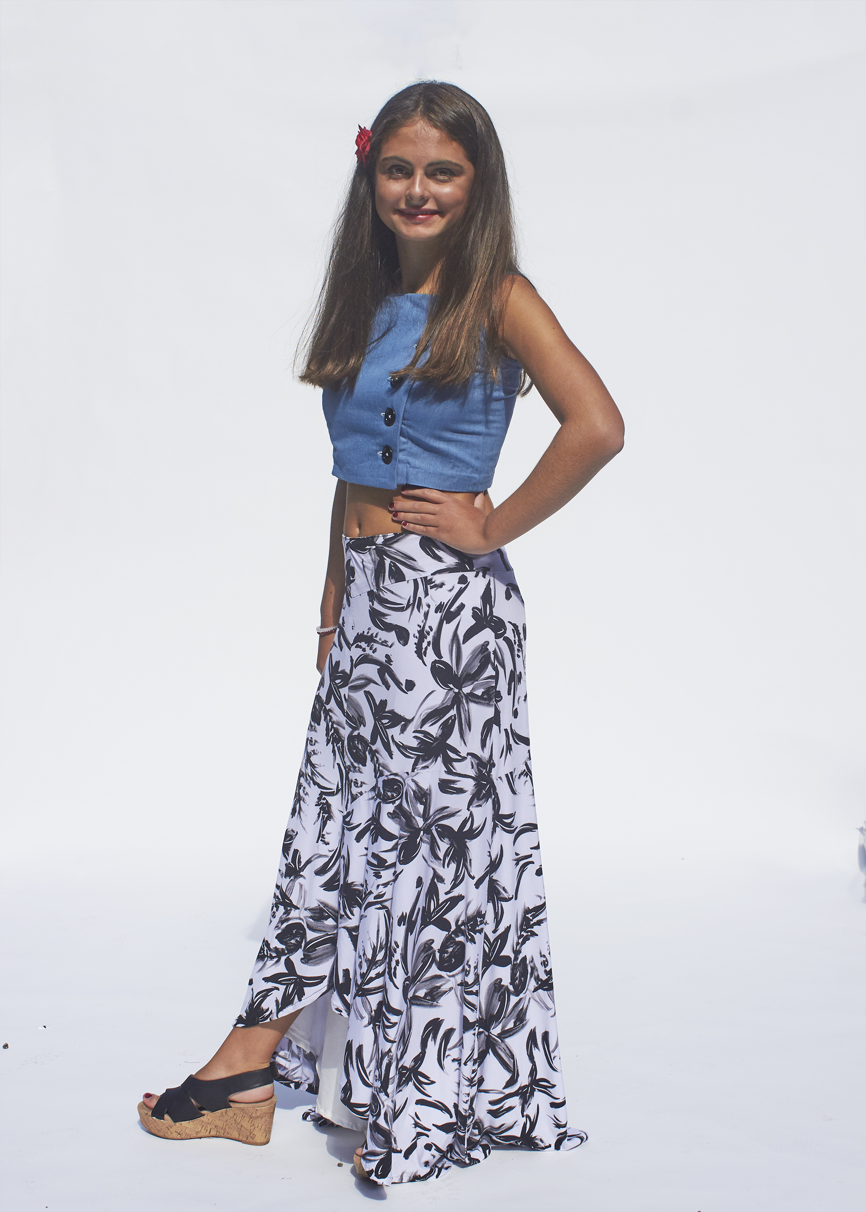 Girl posing in denim button up top and black and white floral skirt