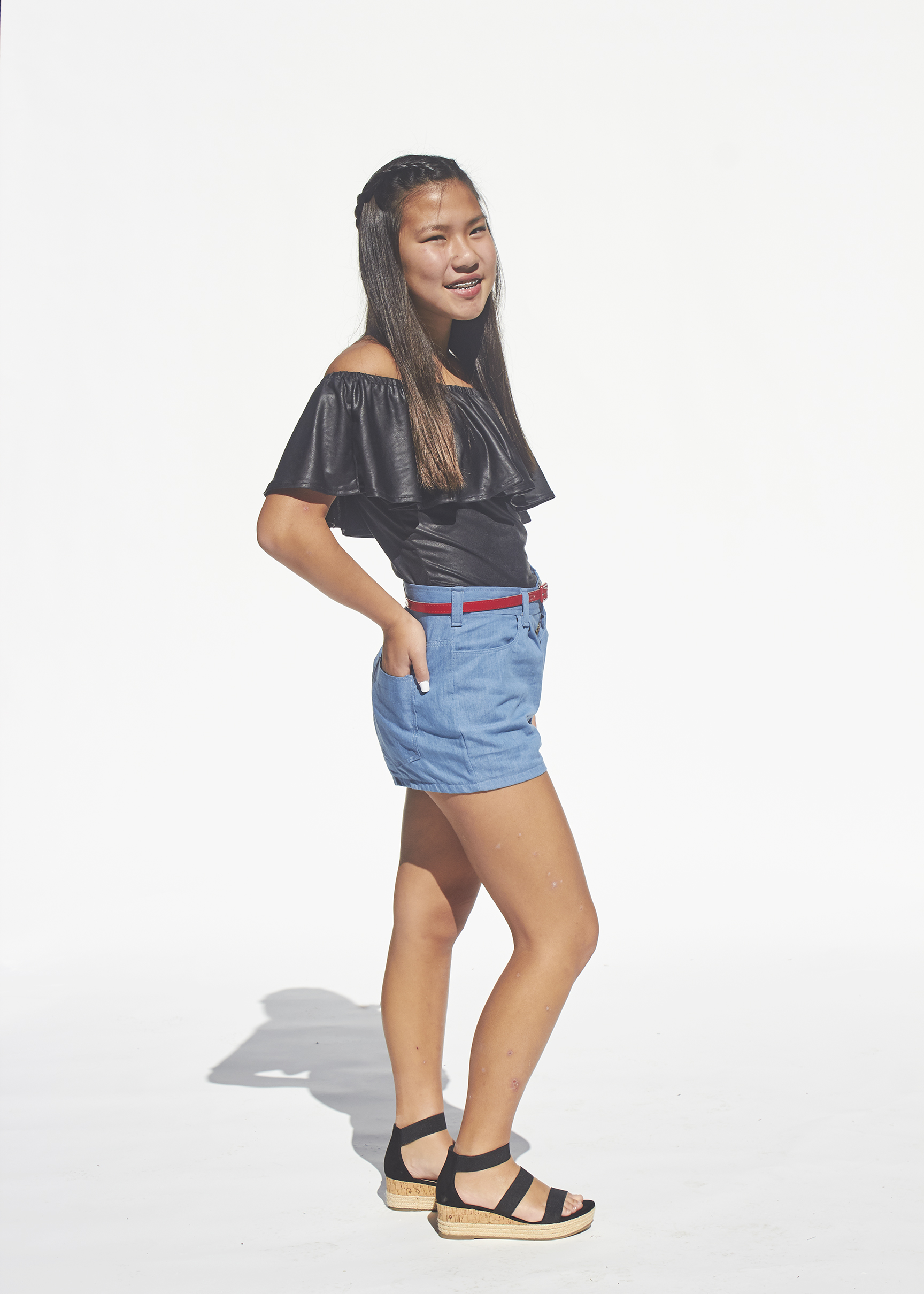 Side view of Photo of denim shorts and black flounced top 