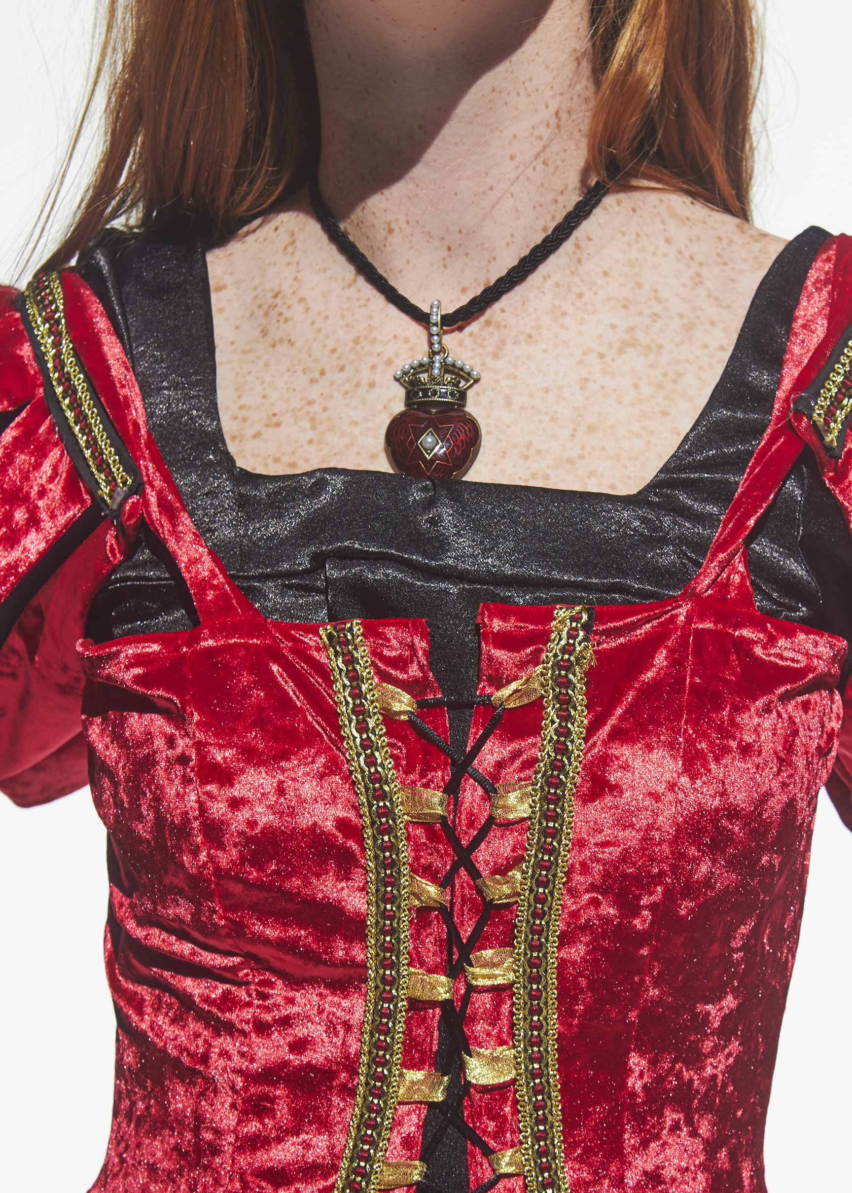 Detail show of red velvet corset with black lacing