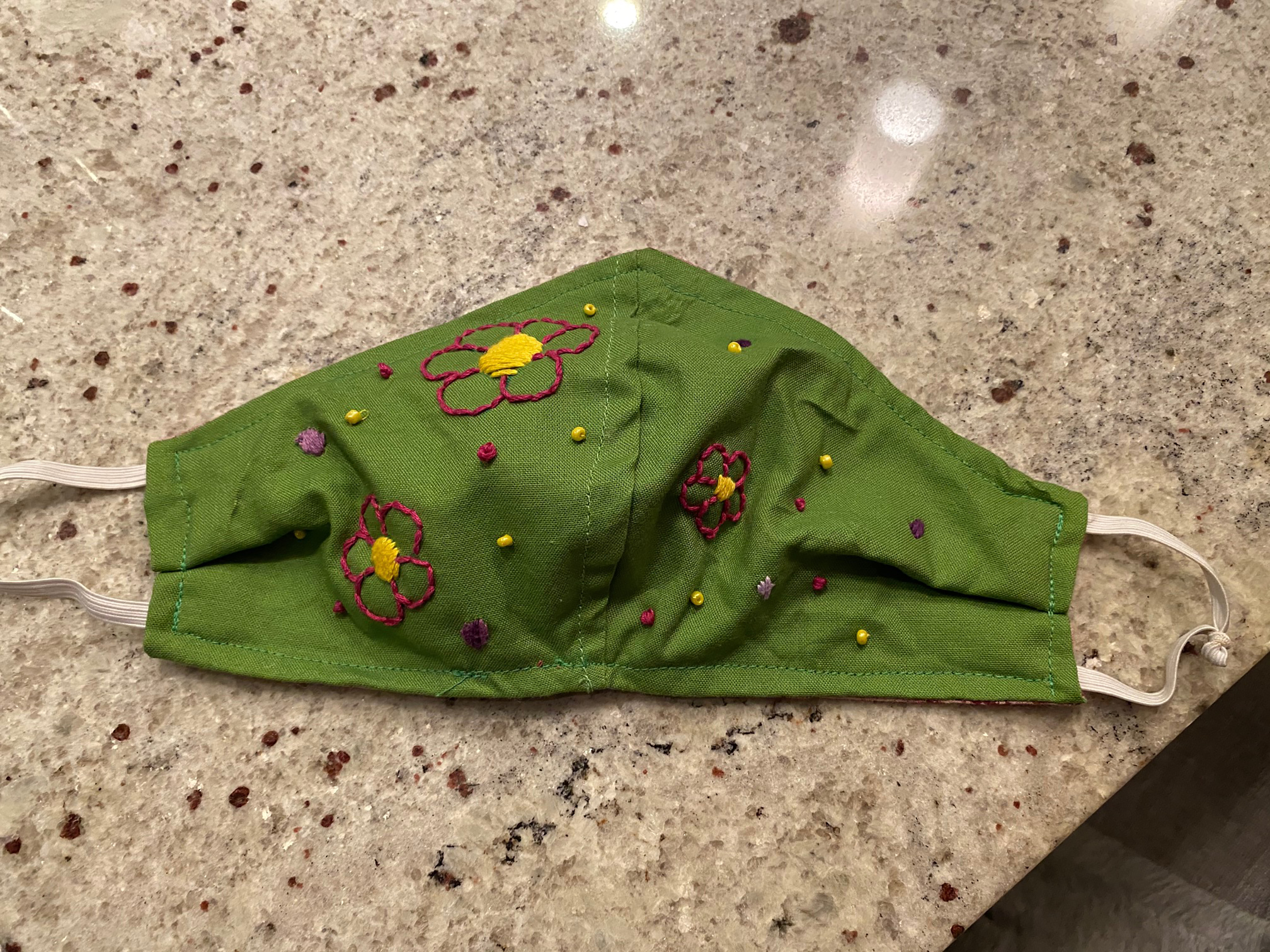 Photo of Green face mask with embroidered flowers