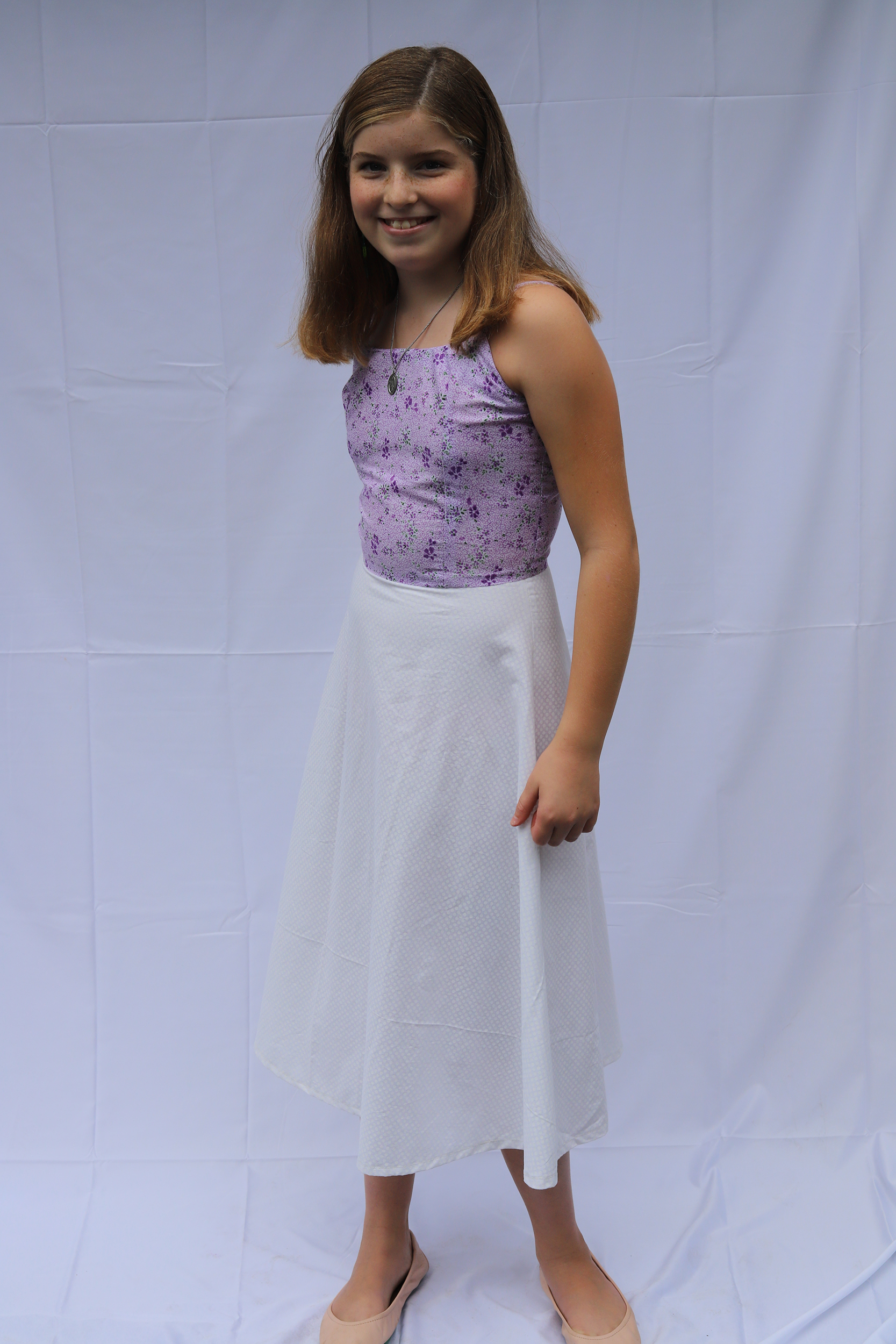 Girl posing a purple and white 50s style dress