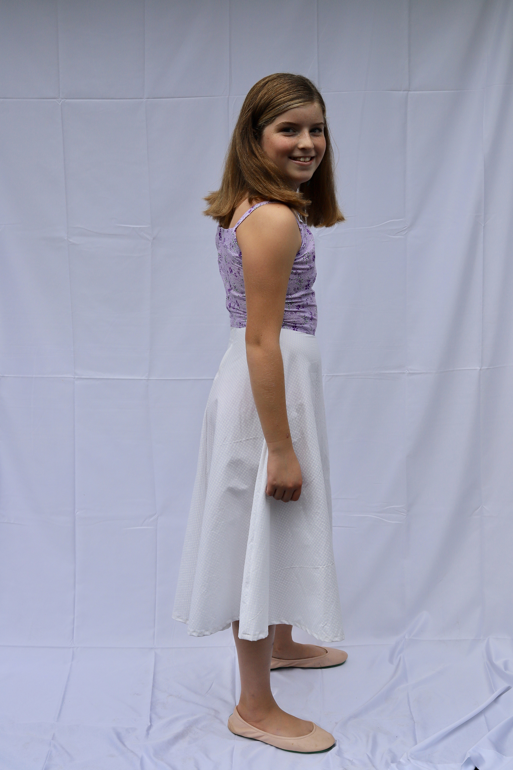 Side view of girl posing a purple and white 50s style dress