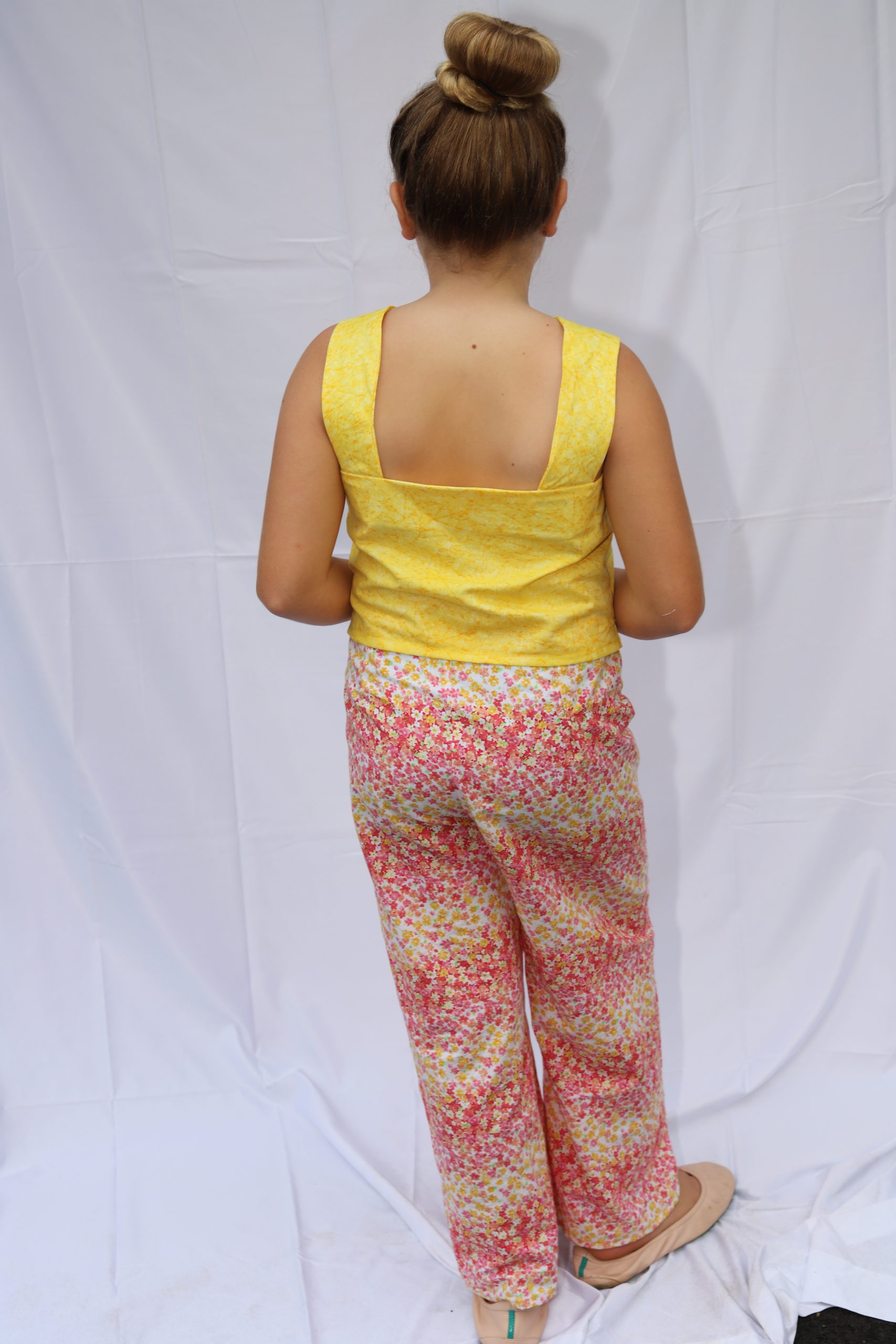 Back view of floral pink and yellow pants with bright yellow top