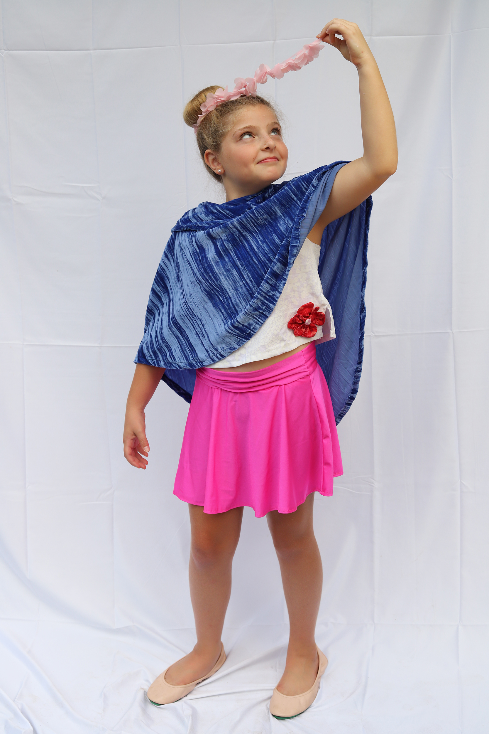 Girl posing in velvet cape and hot pink skirt