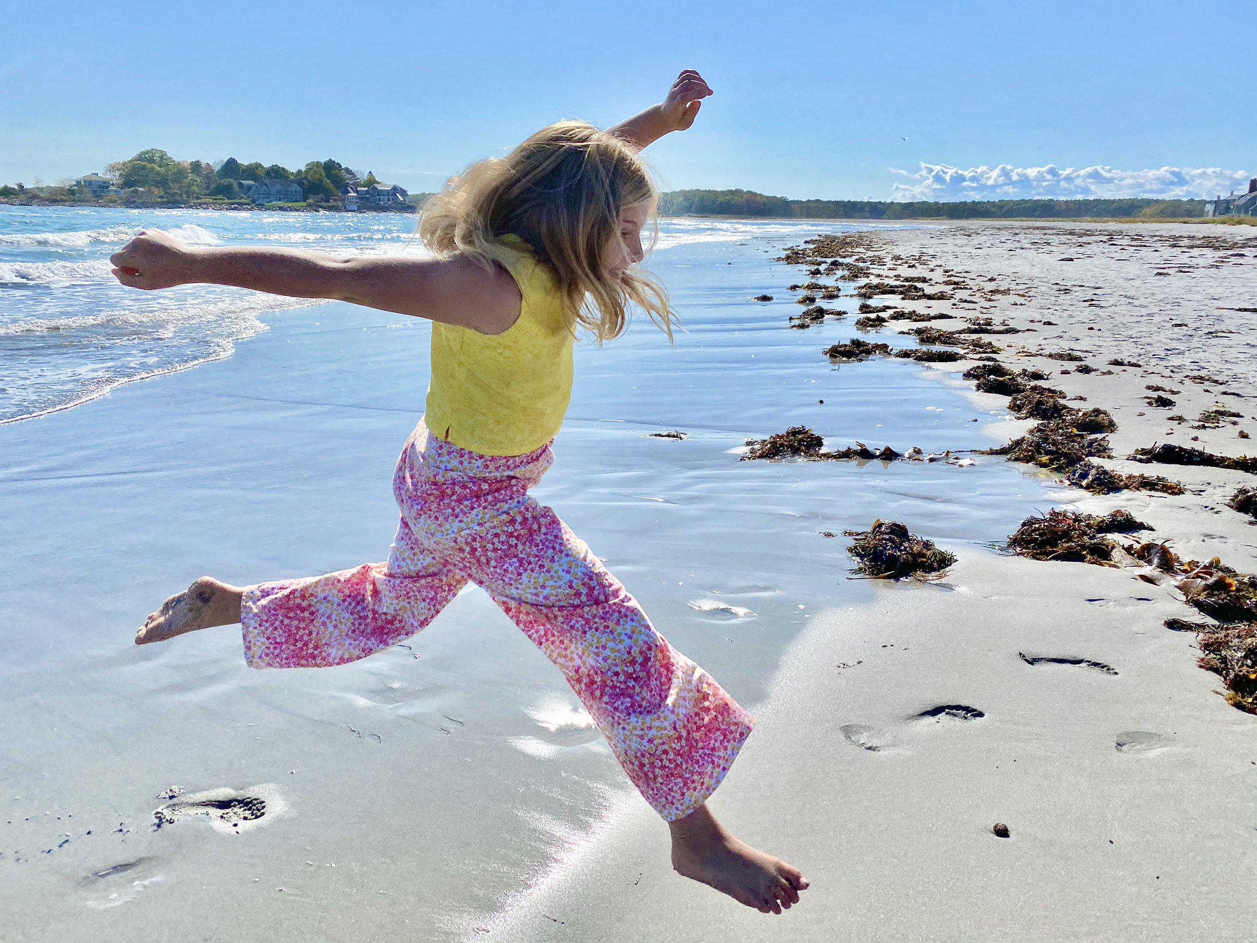 Girl leaping in the sand at the beach