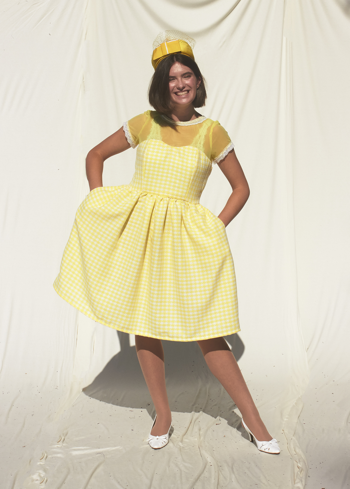 Smiling model wearing a fifties yellow dress