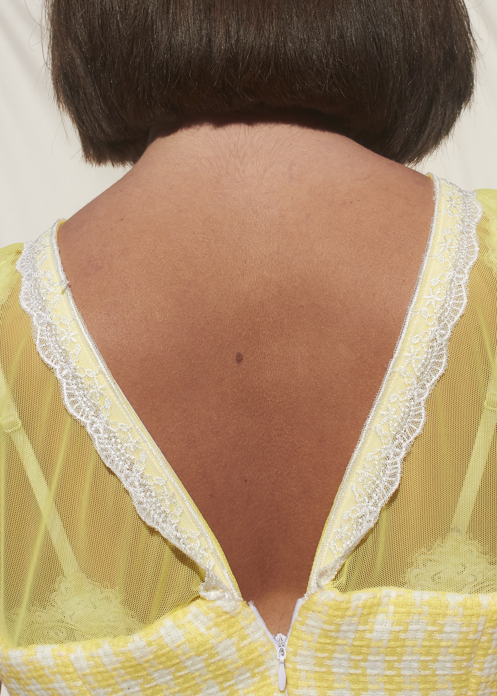 Back of a dress with lace and sheer yellow fabric