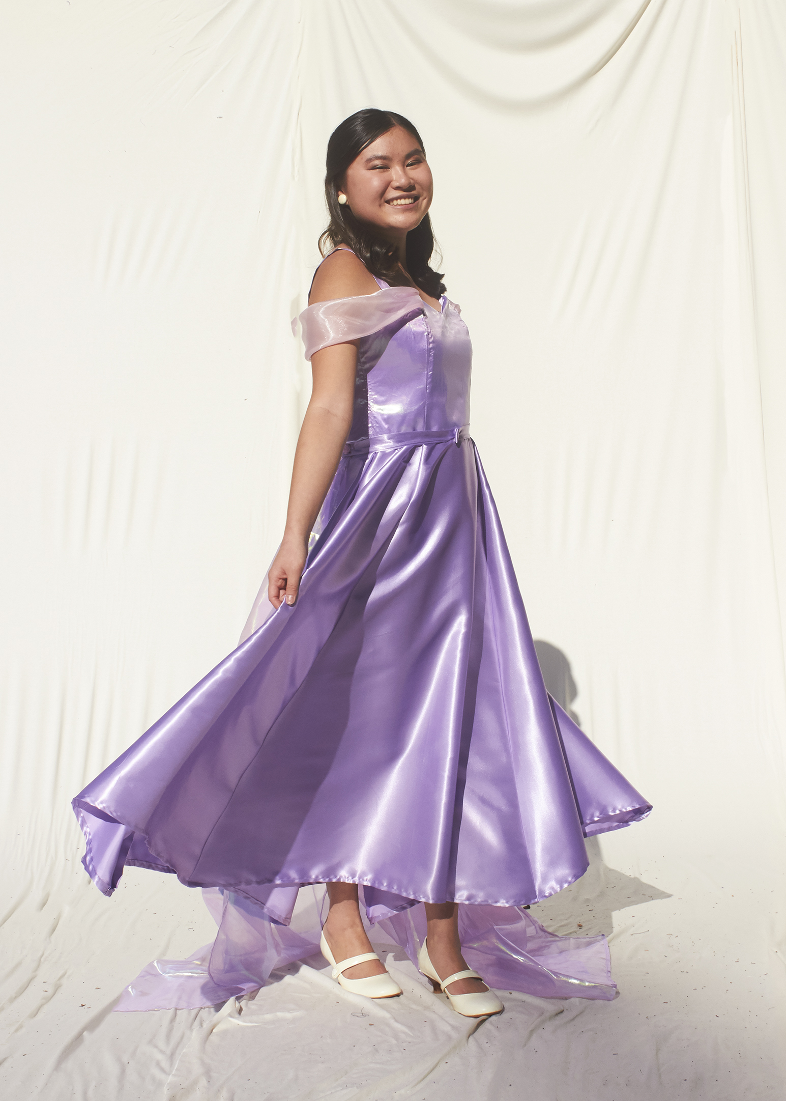 Girl spinning in lavender tea length gown with sheer train