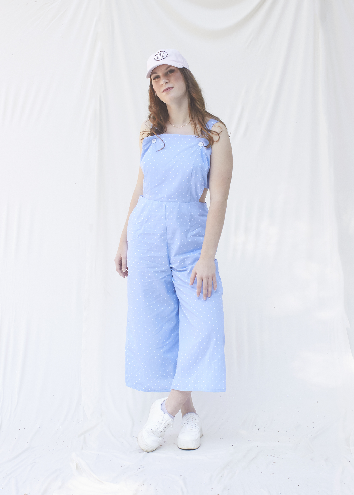 Teenage girl stand in a light blue cut out jumpsuit