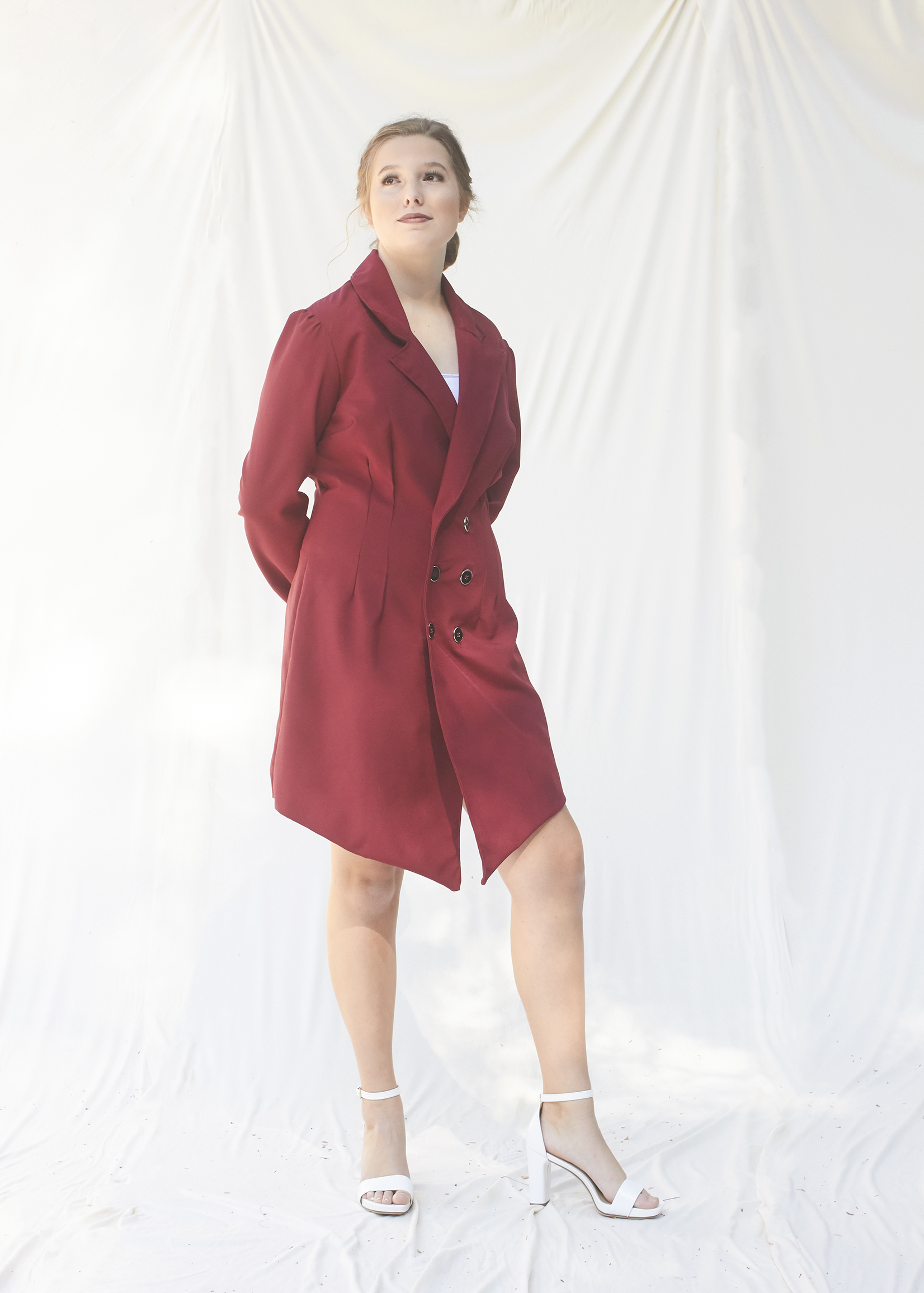 Three quarter view of burgundy power suit dress