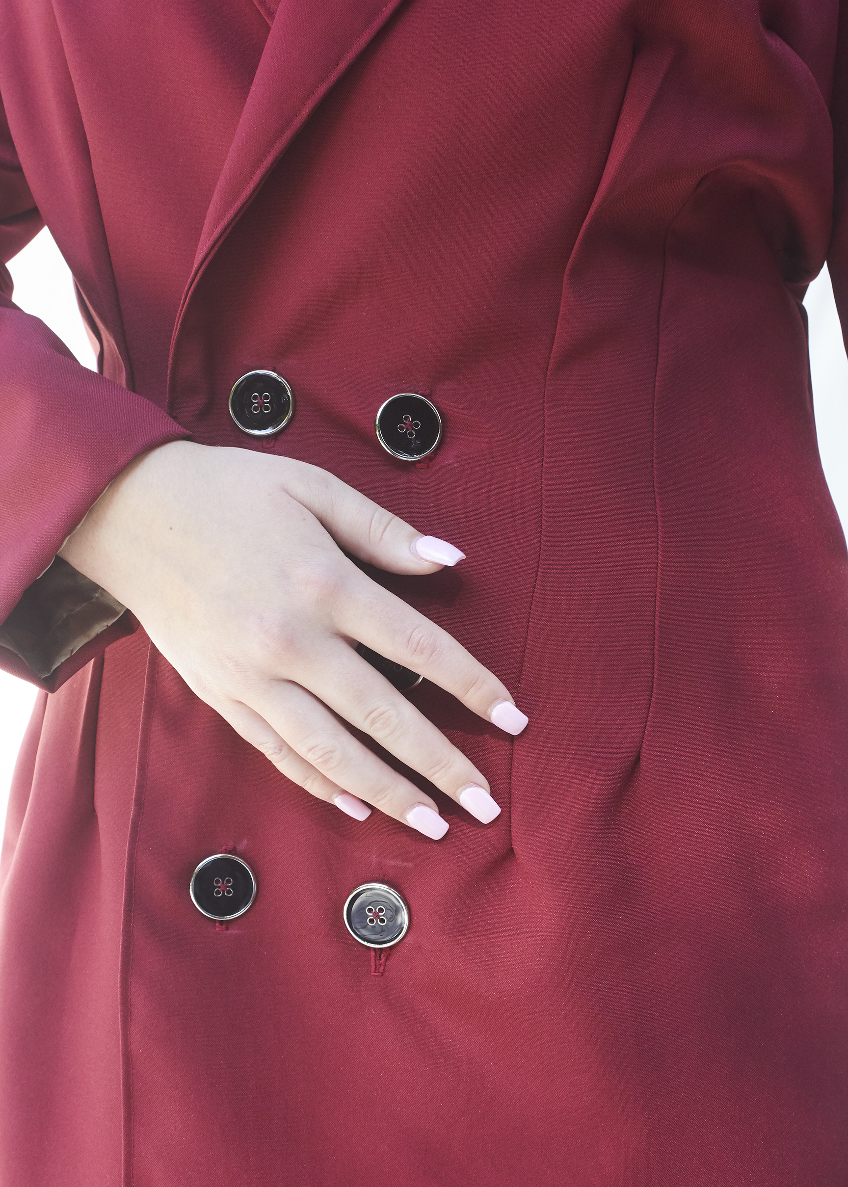 Close up photo of a hand laying on suit buttons