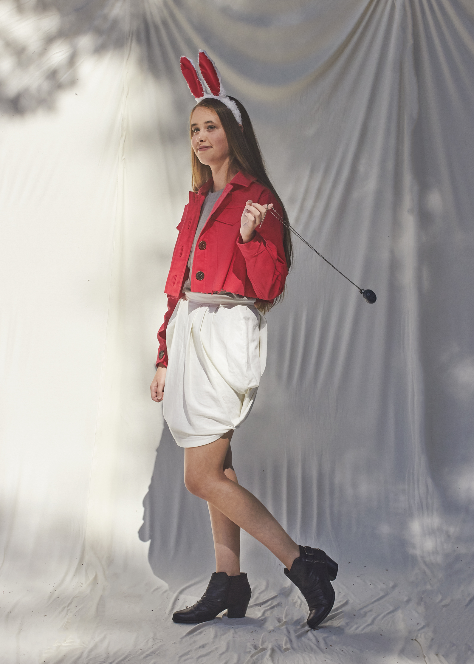 Girl posing in a white rabbit outfit that is made up of a red denim cropped jacket and white draped mini skirt