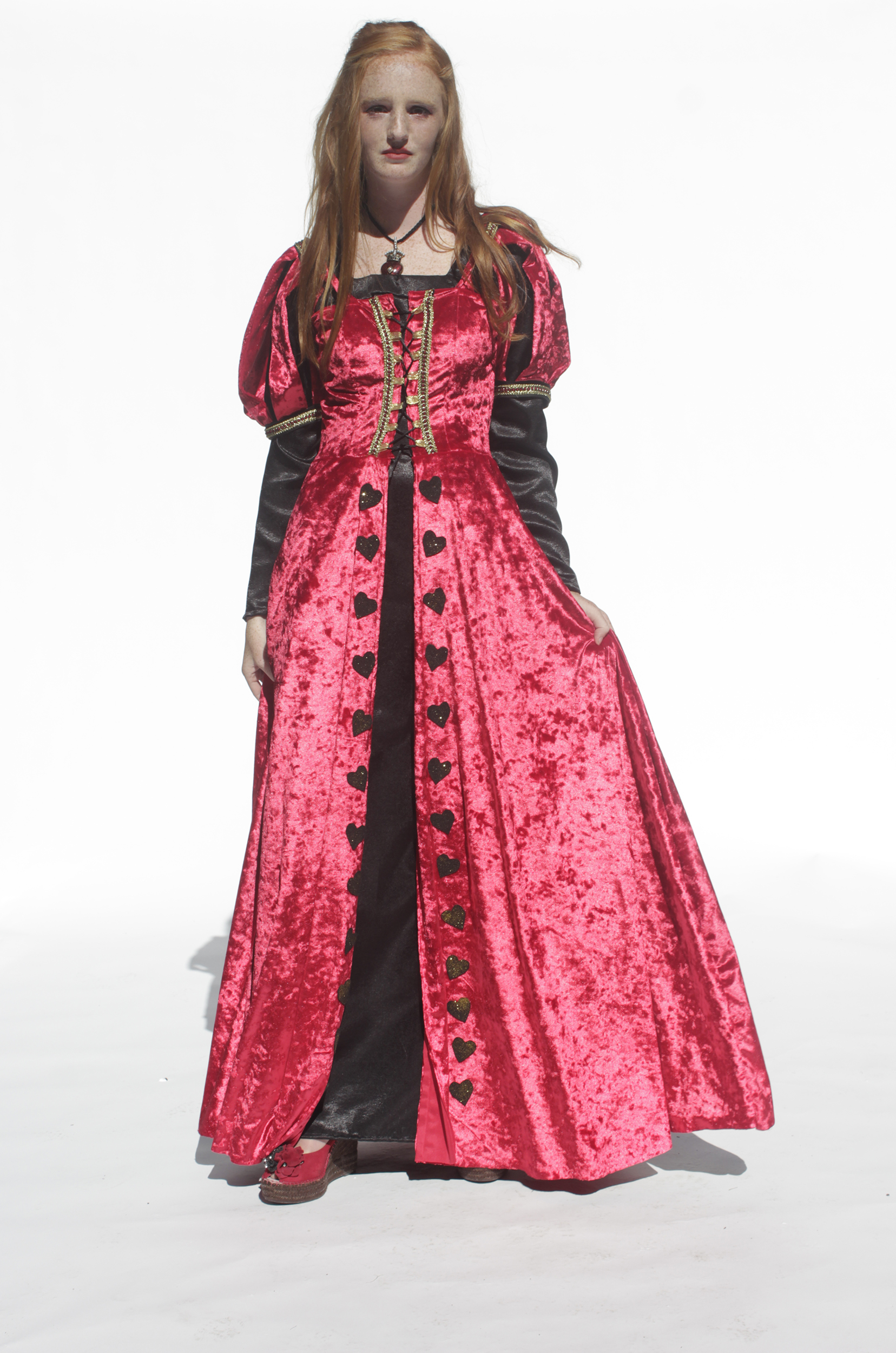 From view of girl spinning in red velvet queen of hearts costume