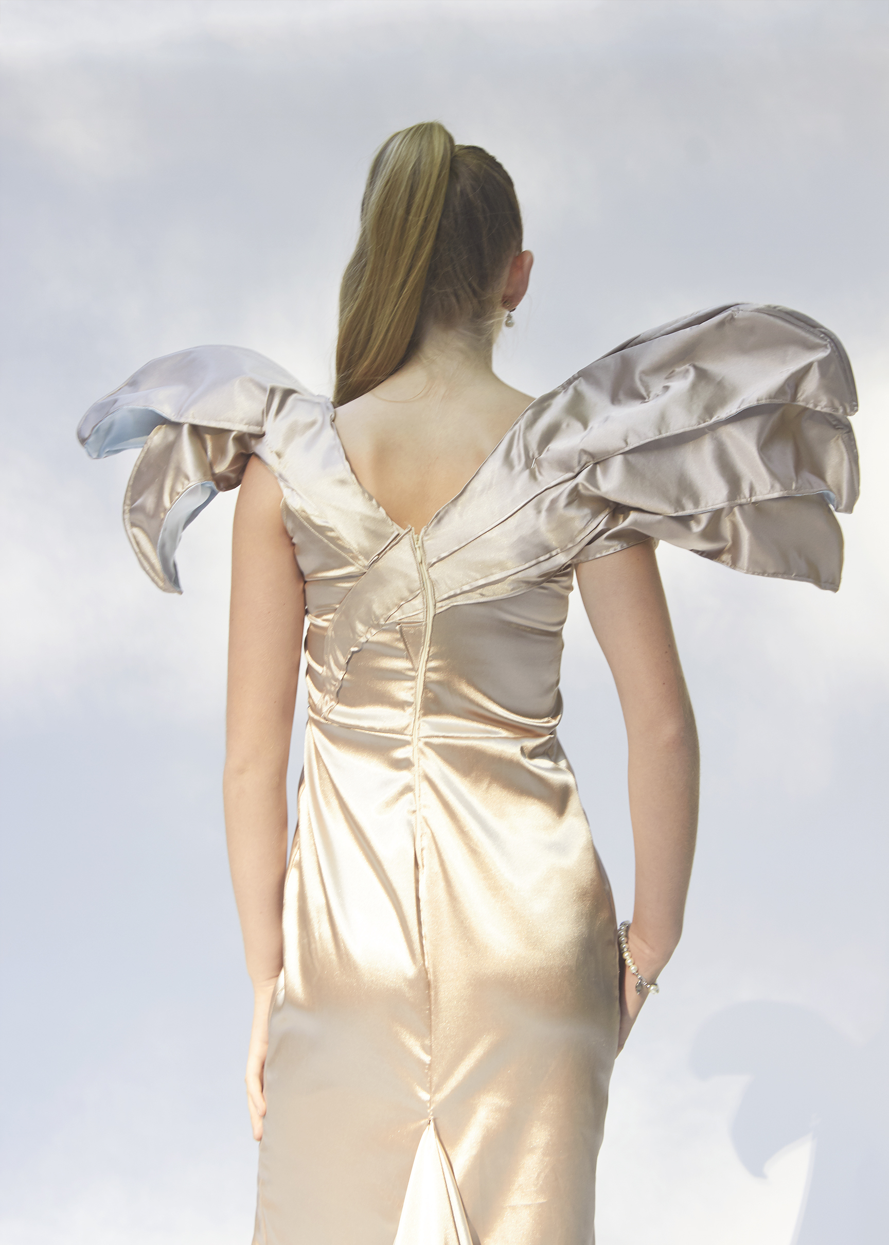 Back view of gold gown with assymettical sleeves