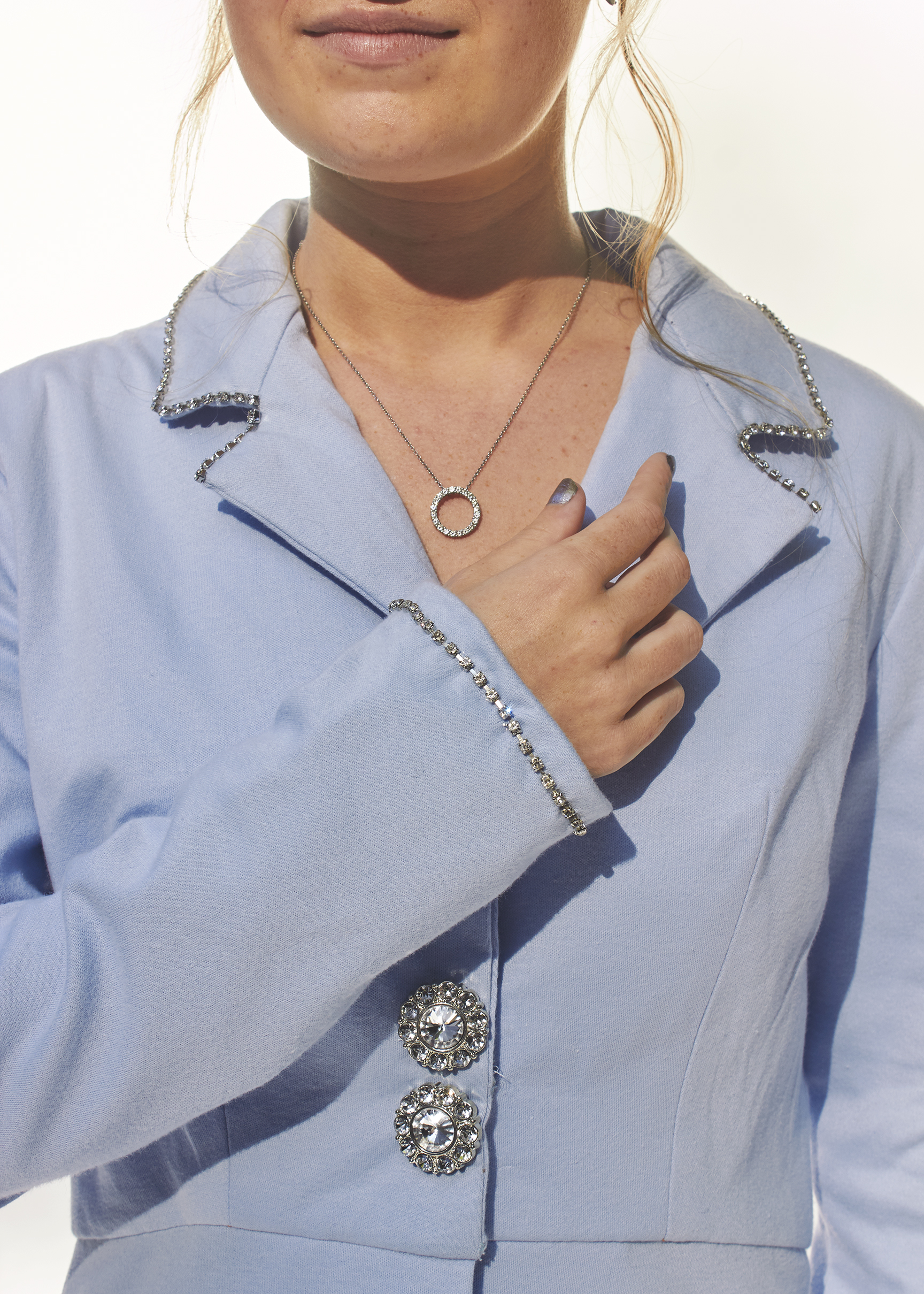 Photo of detail show of sky blue blazer with silver trim sleeve cuff