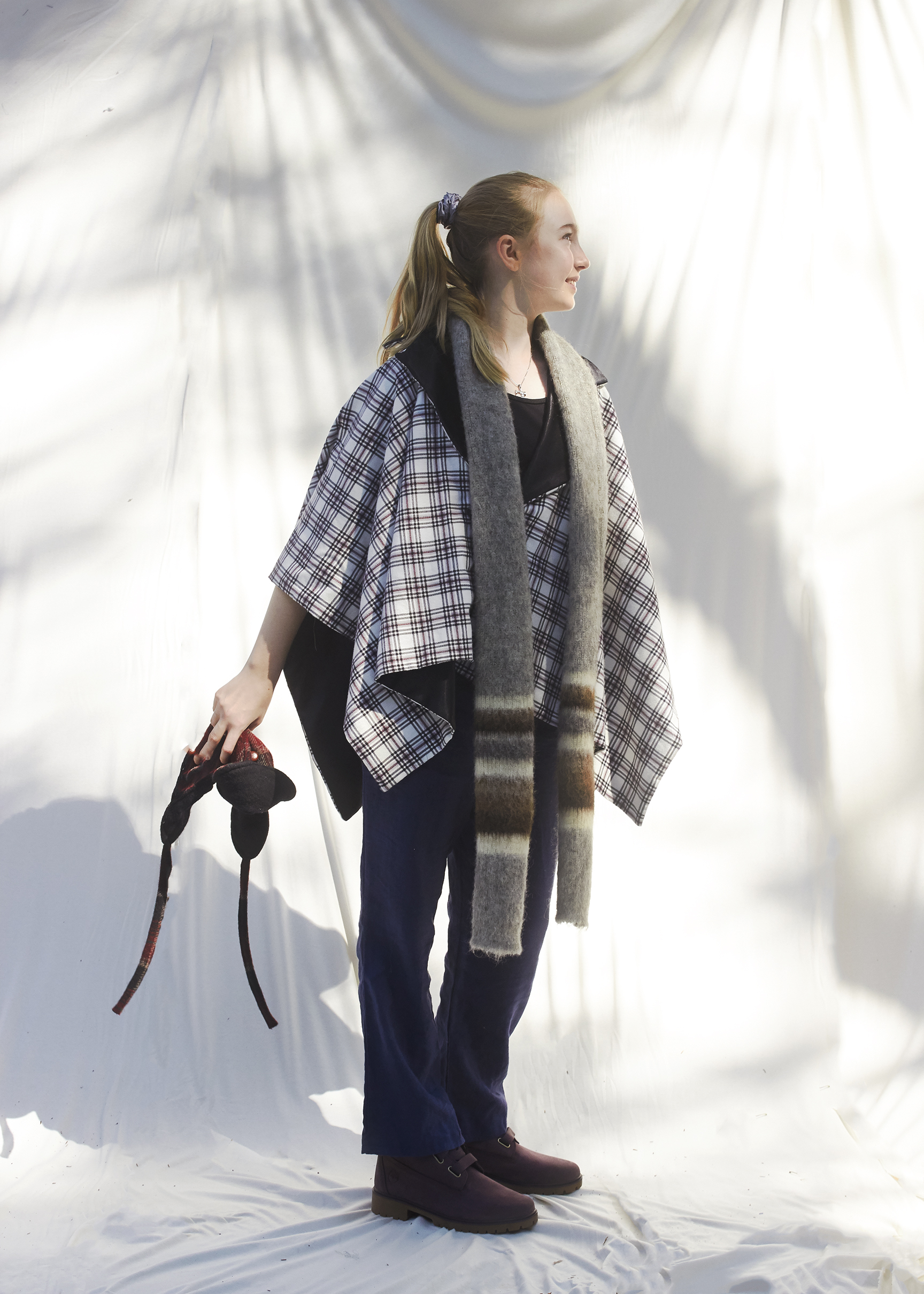 Young Girl Standing in a three quarter view pose wearing a winter poncho