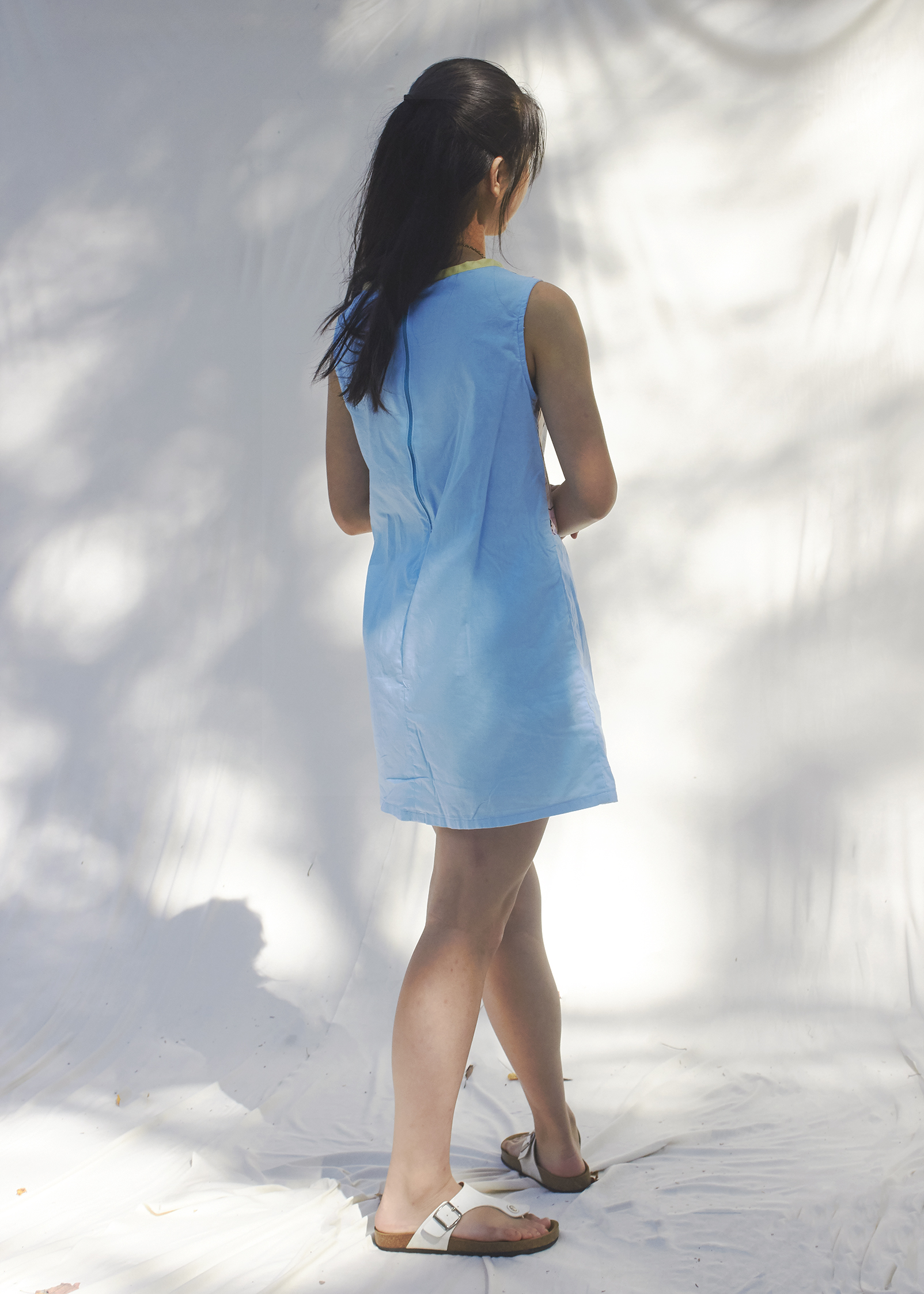 Back view of a girl dressed in a pastel blue color block dress