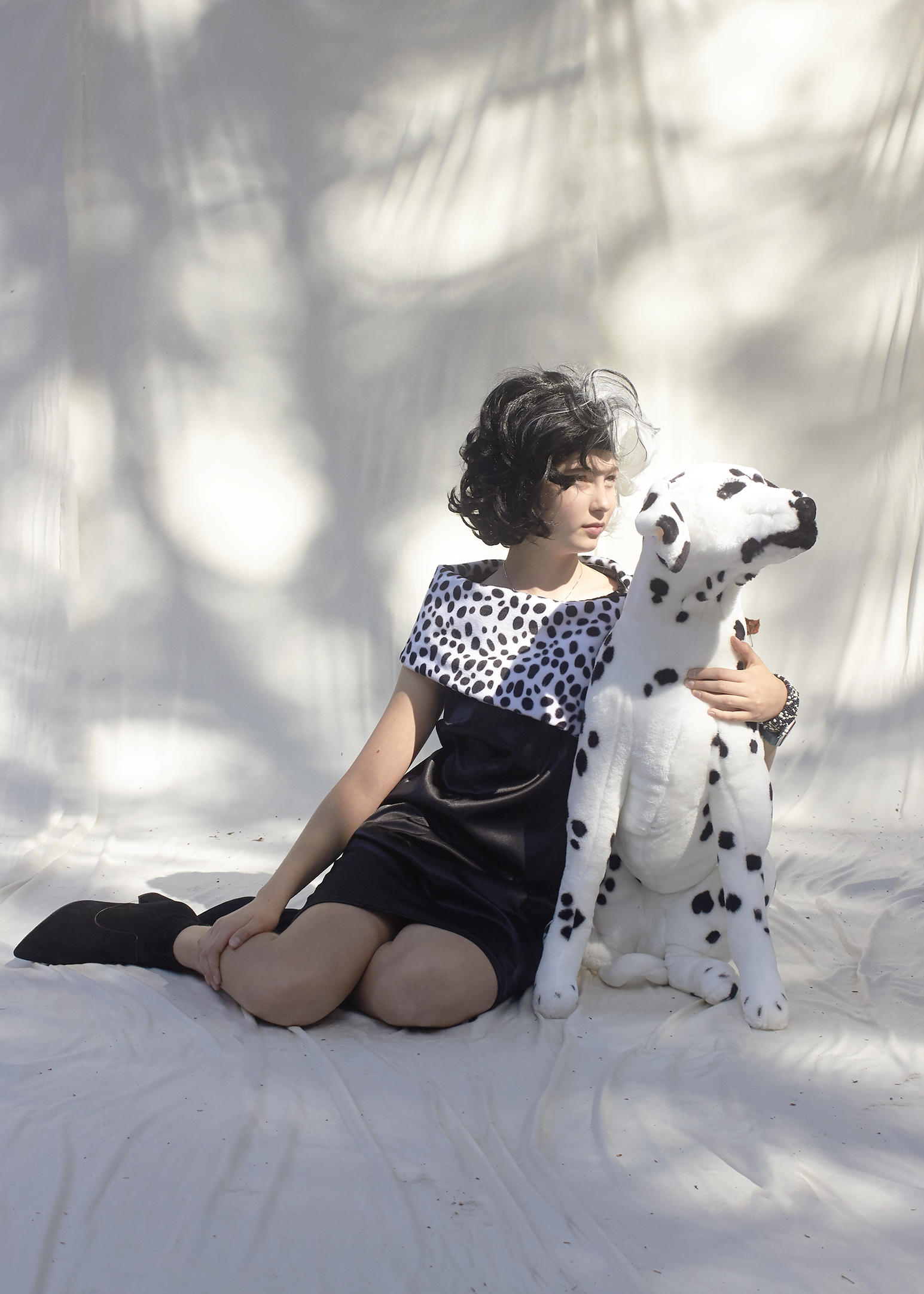 Photo of Girl in Cruella Deville Dress sitting with a fake Dalmatian